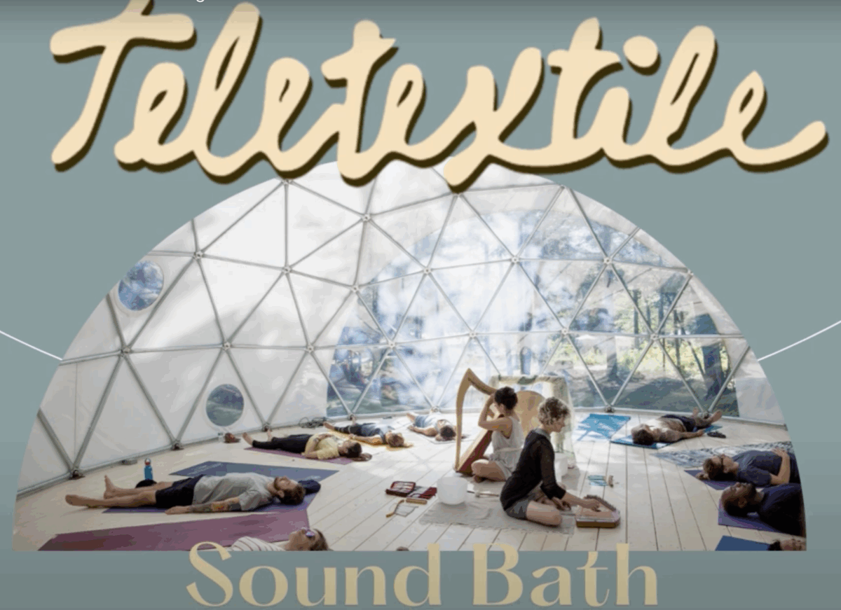 6 people laying on the floor on yoga mats in a circular formation under a clear geodesic dome structure with a harpist and another music sitting in the middle.